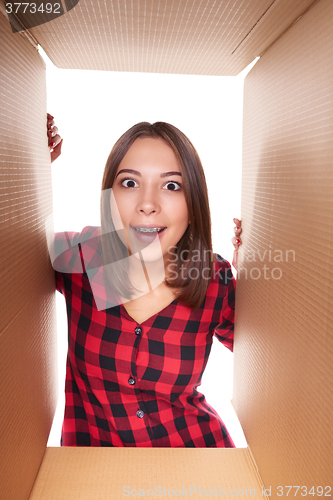 Image of Girl opening a carton box and looking inside