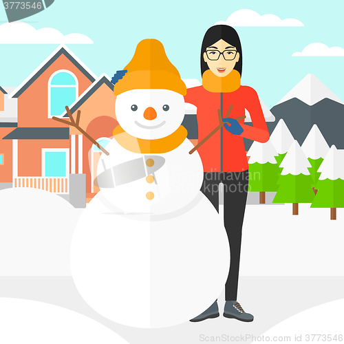 Image of Woman posing near snowman.