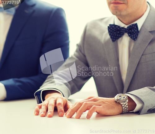 Image of close up of happy male gay couple hands on wedding