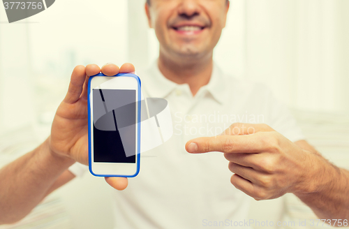 Image of close up of happy man with smartphone at home