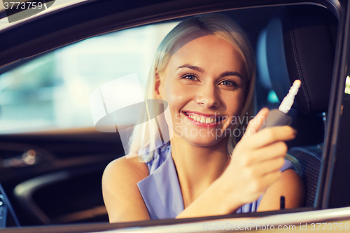 Image of happy woman getting car key in auto show or salon