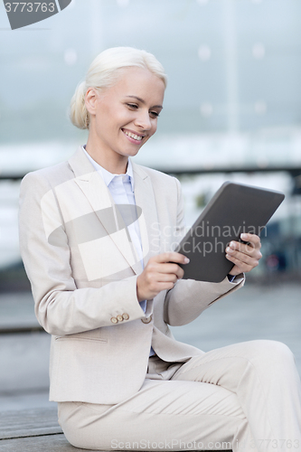 Image of smiling businesswoman with tablet pc outdoors