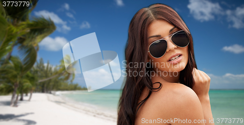 Image of young woman with sunglasses on beach