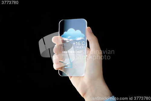 Image of close up of hand with weather app on smartphone