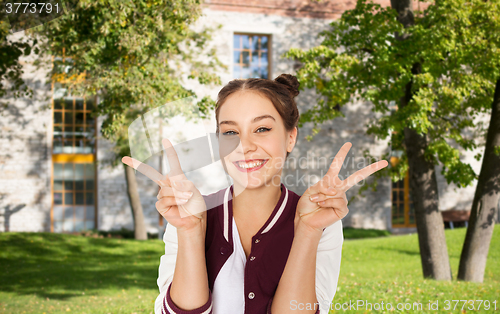 Image of happy teenage student girl showing peace sign