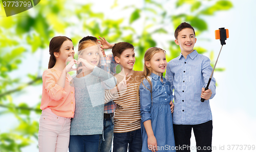 Image of happy children with smartphone and selfie stick