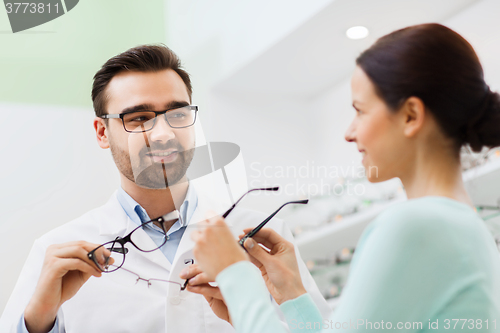 Image of woman and optician showing glasses at optics store