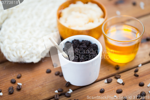 Image of close up of coffee scrub in cup and honey on wood