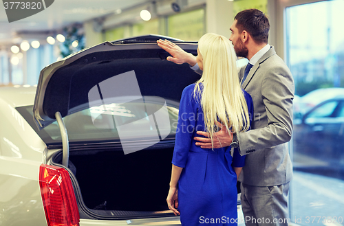 Image of happy couple choosing car in auto show or salon