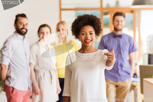 Image of woman pointing to you over creative office team