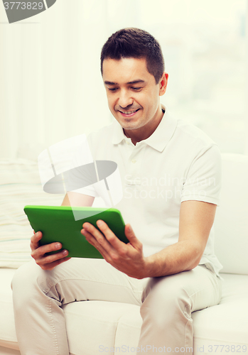 Image of smiling man working with tablet pc at home