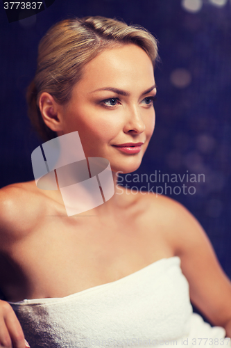 Image of beautiful young woman sitting in bath towel