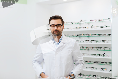 Image of man optician in glasses and coat at optics store