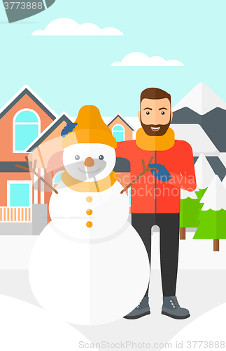 Image of Man posing near snowman.