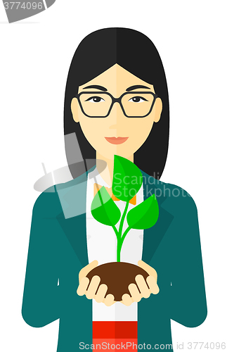 Image of Woman holding plant.