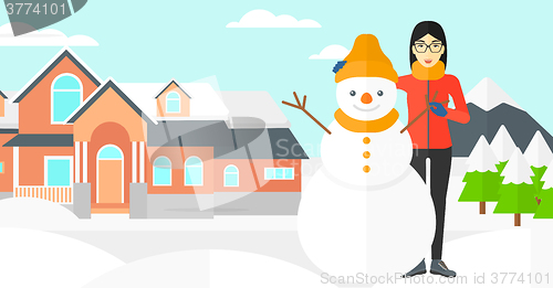 Image of Woman posing near snowman.