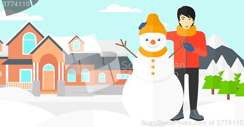 Image of Man posing near snowman.