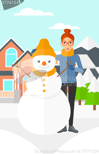 Image of Woman posing near snowman.