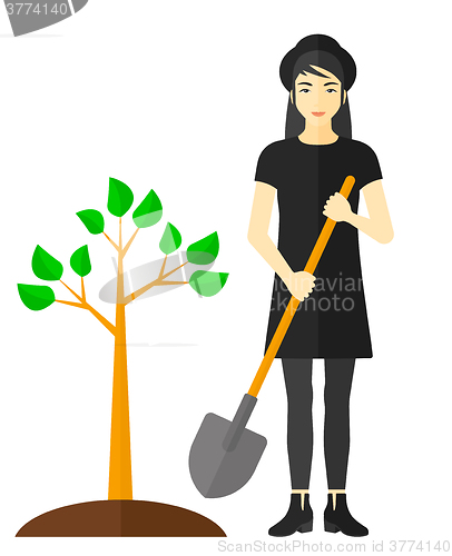 Image of Woman plants tree.