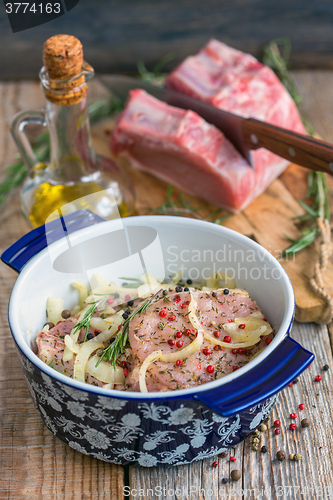 Image of Pork chops in a pan on the old table.