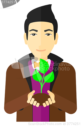 Image of Man holding plant.