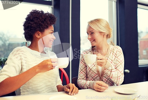 Image of happy young women drinking tea or coffee at cafe