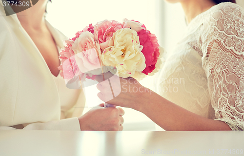 Image of close up of happy lesbian couple with flowers