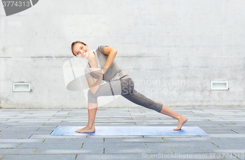 Image of woman making yoga low angle lunge pose on mat