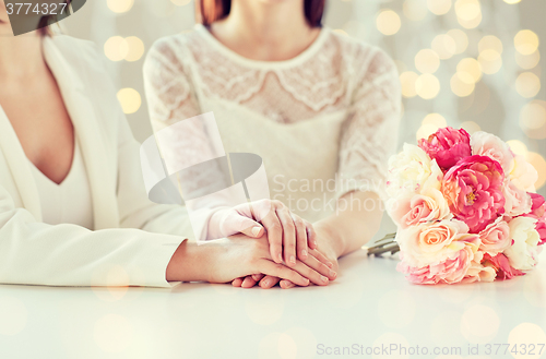 Image of close up of happy lesbian couple with flowers