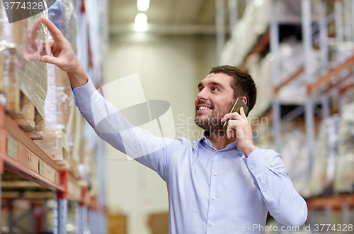 Image of happy man calling on smartphone at warehouse