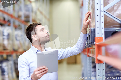 Image of businessman with tablet pc at warehouse