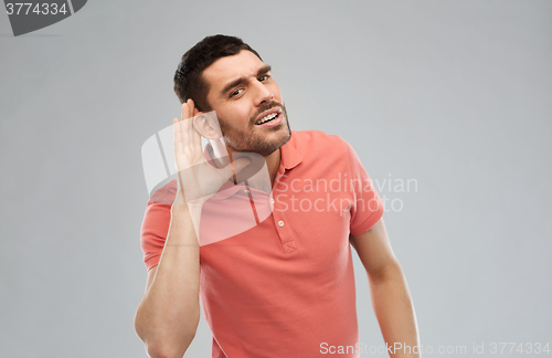 Image of man having hearing problem listening to something