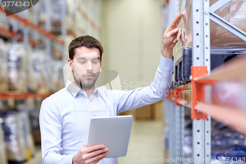 Image of businessman with tablet pc at warehouse