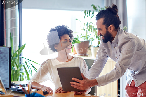 Image of happy creative team with tablet pc in office