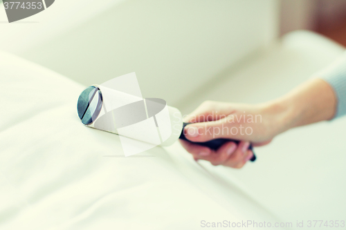 Image of close up of woman hand with sticky roller cleaning