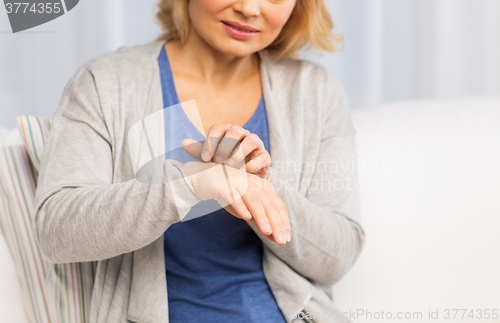 Image of close up of woman suffering from hand inch at home