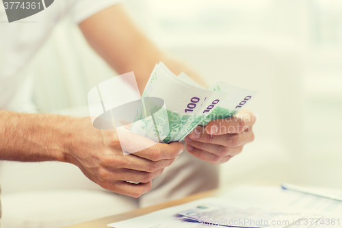 Image of close up of man hands counting money at home