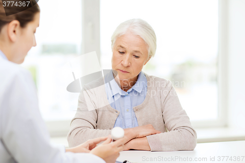 Image of doctor with medicine and senior woman at hospital