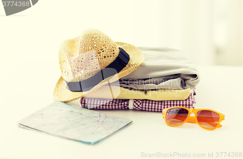 Image of close up of summer clothes and travel map on table