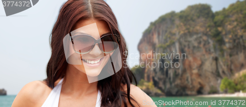 Image of smiling young woman with sunglasses on beach