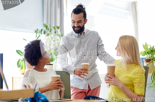 Image of happy creative team drinking coffee in office