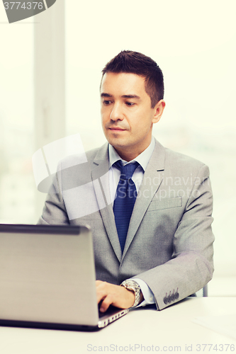 Image of businessman working with laptop in office