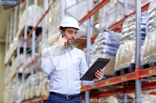 Image of man with clipboard and smartphone at warehouse