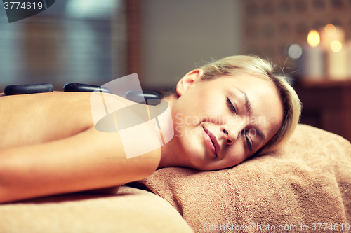 Image of close up of woman having hot stone massage in spa