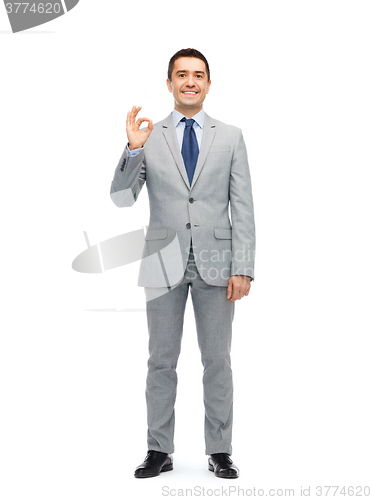 Image of happy businessman in suit showing ok hand sign