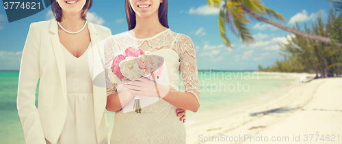 Image of close up of happy lesbian couple with flowers