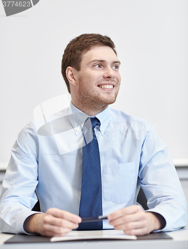 Image of smiling businessman sitting in office