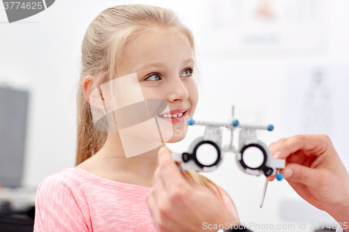 Image of optician with trial frame and girl at clinic