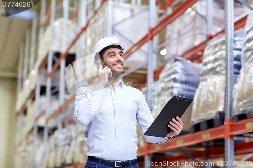 Image of man with clipboard and smartphone at warehouse