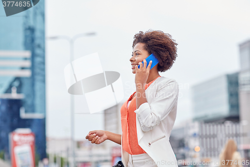 Image of happy african businesswoman calling on smartphone